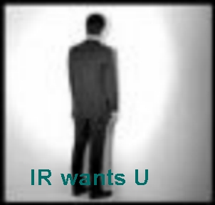 A person in a suit standing with their back to the camera, in a darkened space with a spotlight effect, featuring the text 'IR wants U' in teal.