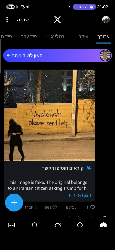 A person standing in front of a wall with graffiti that reads 'Ayatollah please send help' at night.